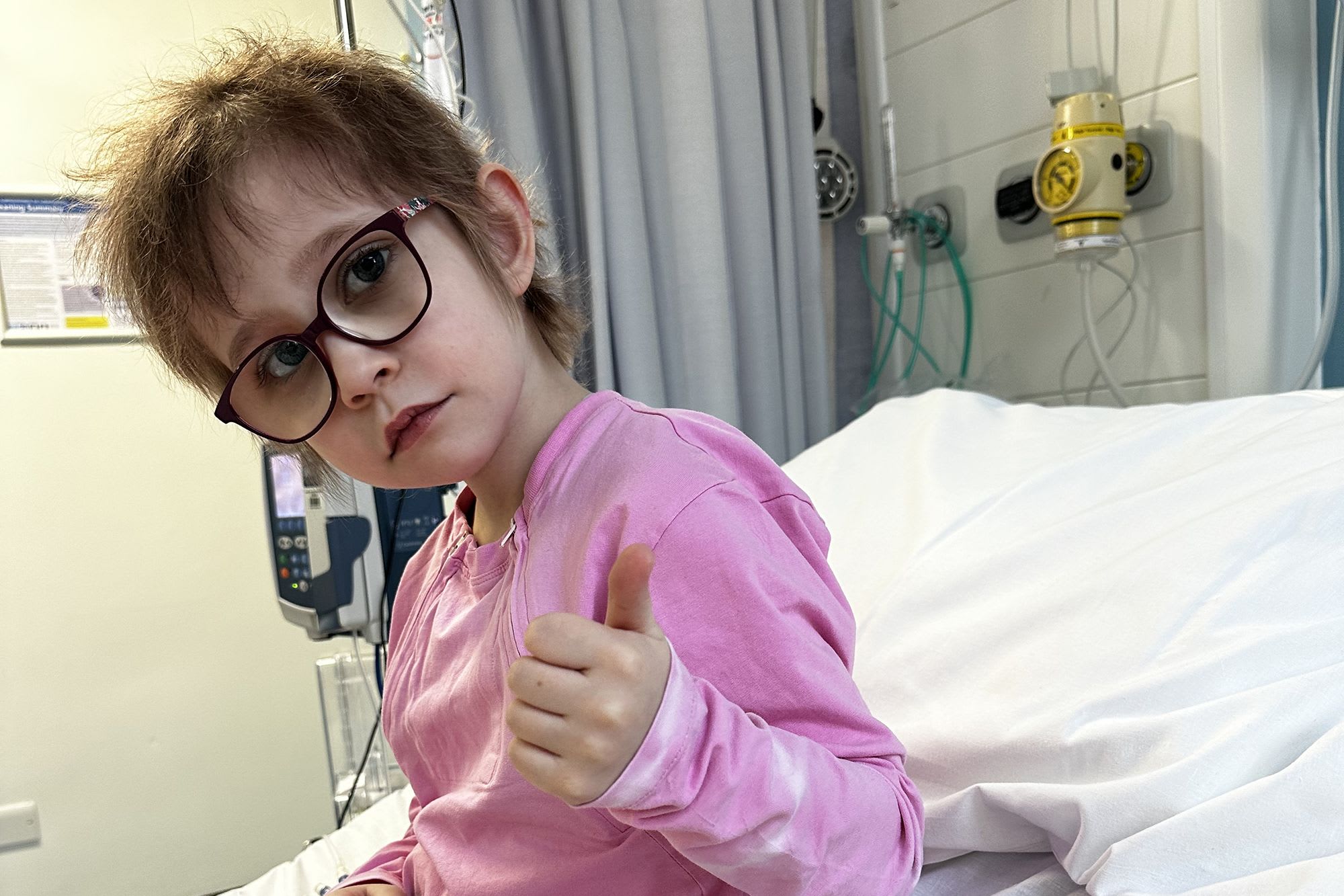 Landscape Dulcie with thumbs up on hospital bed