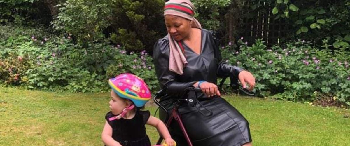 Nonly in her wheelchair next to her daugher Nandi on a bicycle