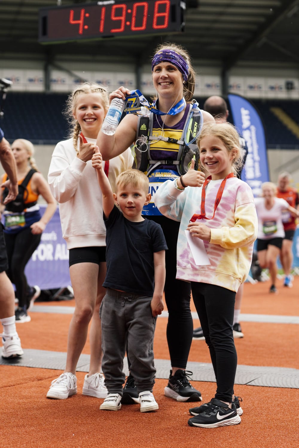 Lindsey Burrow at the finish line of the Rob Burrow Leeds Marathon with her children Maya, Macy and Jackson