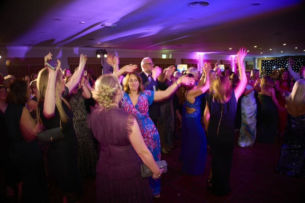 In action shot of group of people dancing at the charity ball