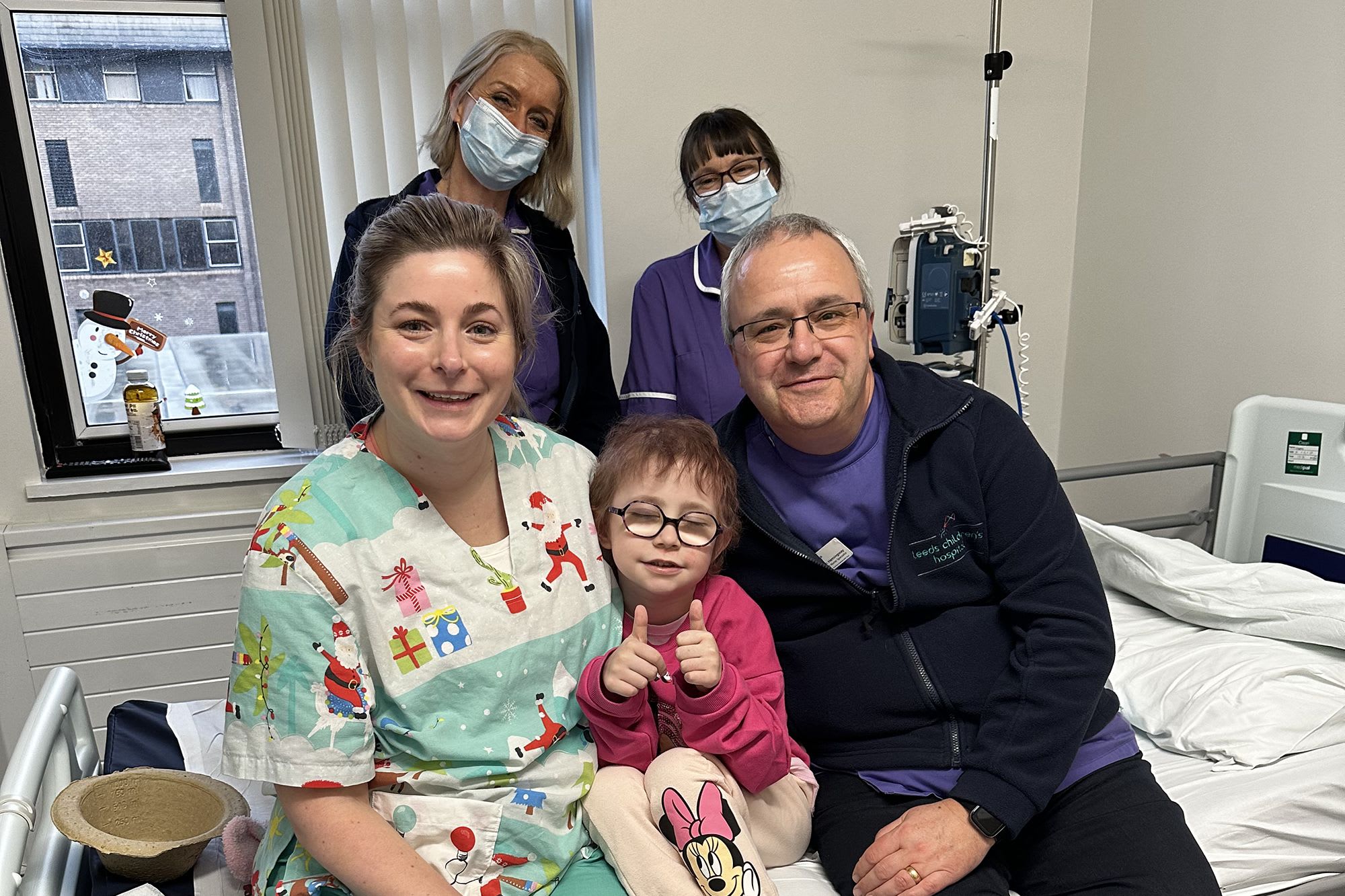 Dulcie with nurses on hospital bed