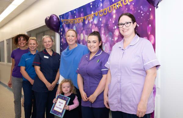Neonatal Staff, Leeds Hospitals Charity representatives, patient Matilda  holding a book of Courage and her mum Alice