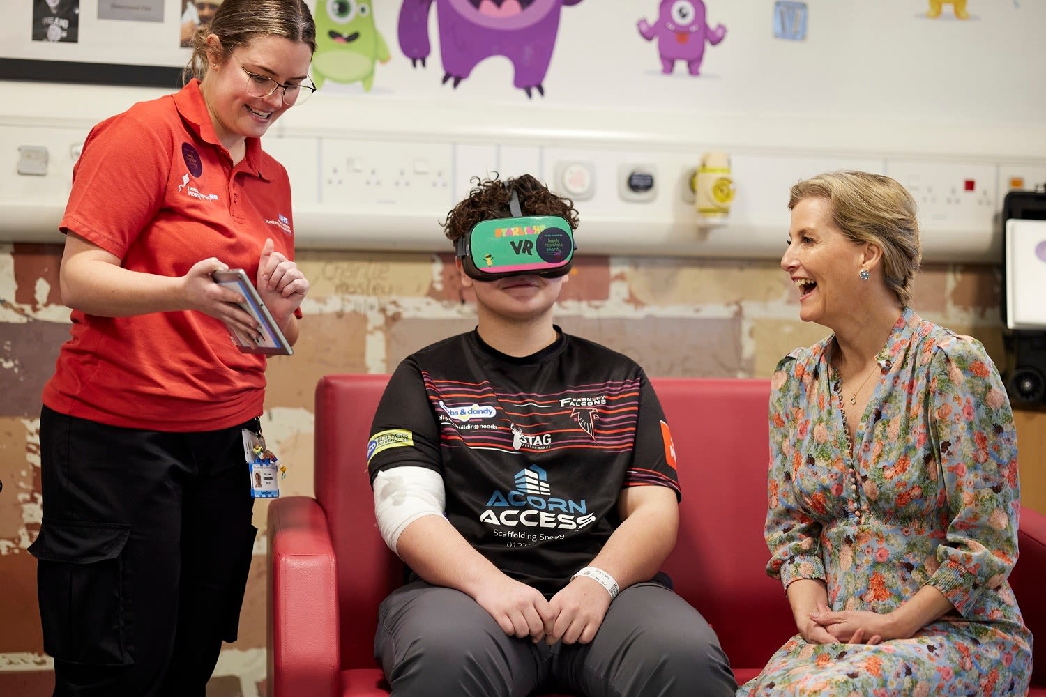 Her Royal Highness The Duchess of Edinburgh watches as 13-year-old Brayden demonstrates VR technology with charity funded VR Play Specialist Lucy Dove