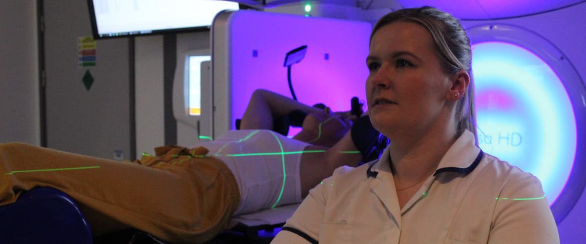 A radiotherapy staff member demonstrating how the SGRT technology works on a mock patient