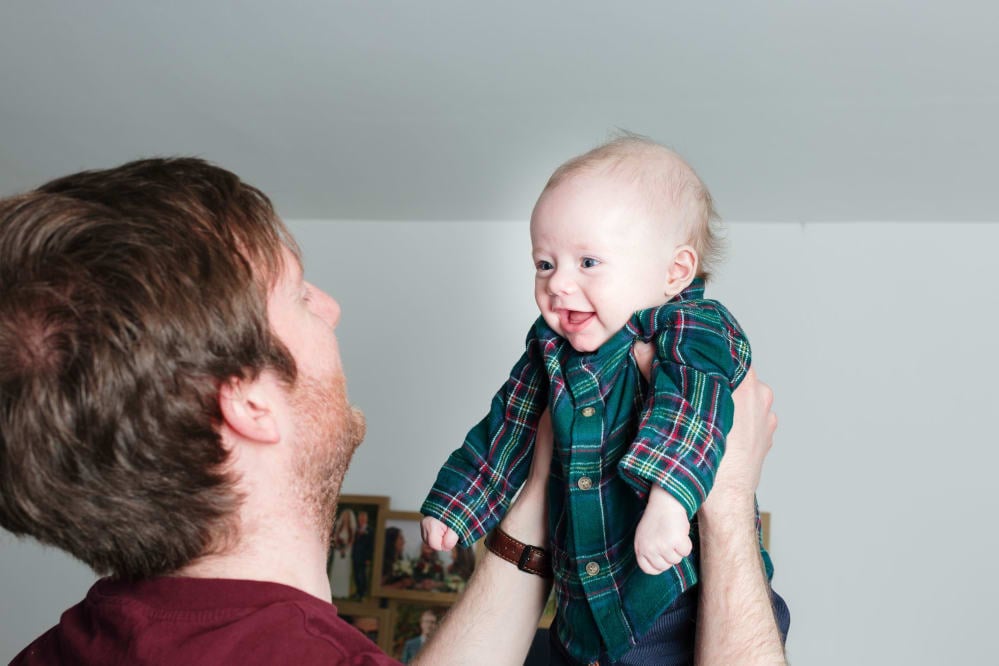 close up of a man holding up a baby