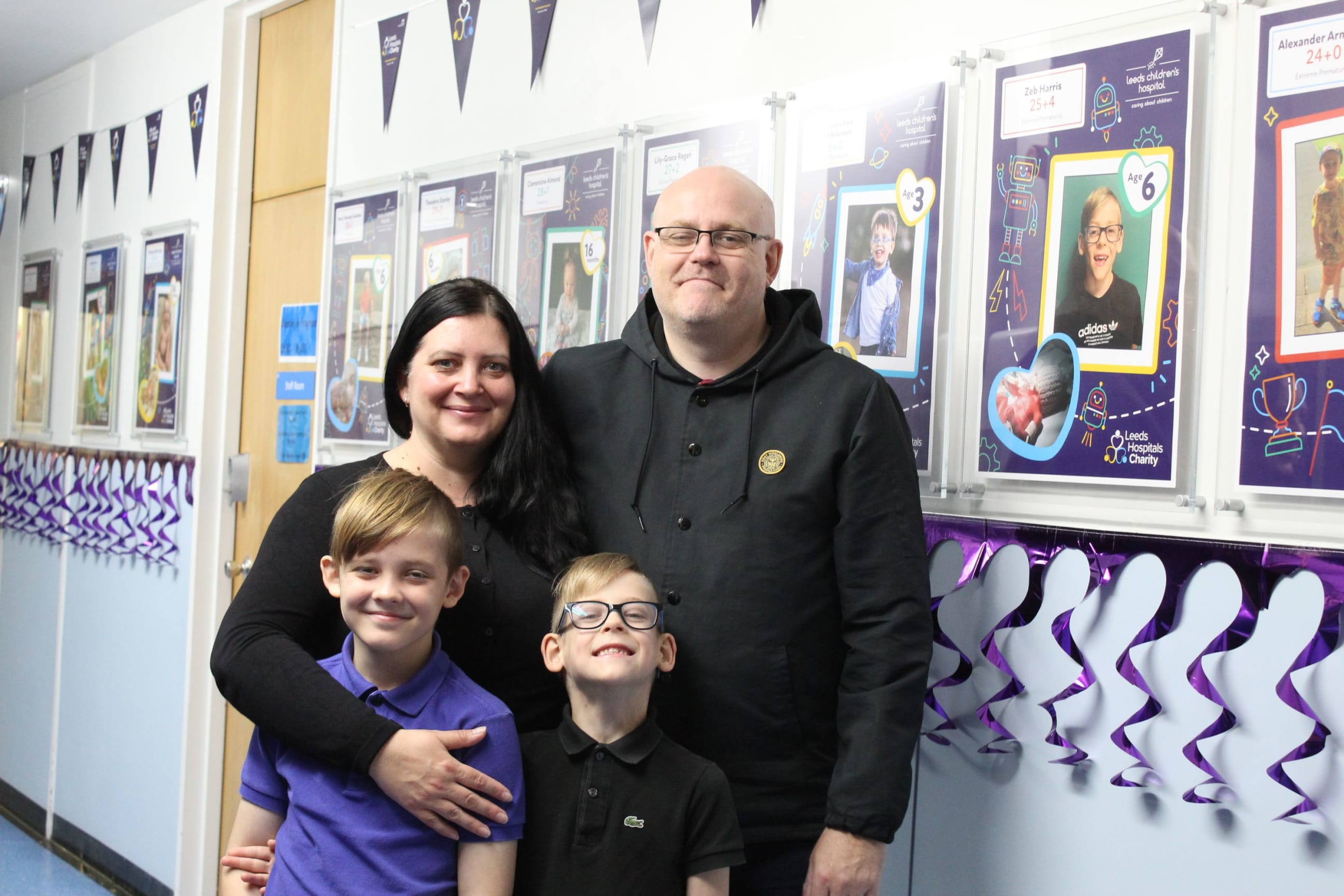 Zeb with his older brother Jonah, mum Sarah and Dad Robin next to his Corridors of Courage photo